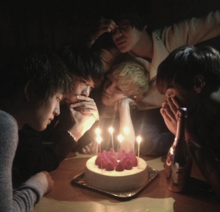 SHINee members looking at a cake